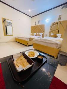 拉合尔Go Guest House Lahore的酒店客房设有两张床和一盘食物