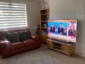 拉德克利夫A secured 3 bedroom family home的带沙发和平面电视的客厅