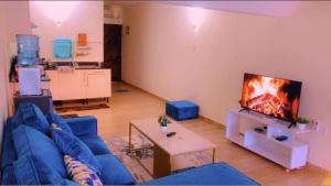 迪亚尼海滩Harmony Homes Beachfront的客厅配有蓝色的沙发和电视