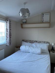 浦耳Luna-Rockley Park Poole的卧室配有白色的床和窗户。