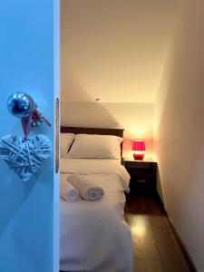 萨拉热窝Sarajevo Sky Suite的一间设有一盏灯的床的房间和一间配有四柱床的房间