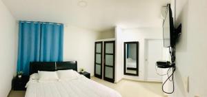 圣安德烈斯Apartahotel Bahia Tropical II的一间卧室配有床和蓝色窗帘