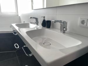 魏玛Ferienwohnung Hospitalgraben的白色浴室水槽和两个水龙头