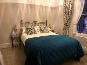 凯西克塔恩豪斯旅馆的一间卧室配有一张带蓝色毯子的床和窗户。
