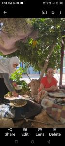 Al Azraq ash ShamālīFamily House的女人正在餐桌上制作比萨饼