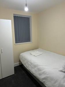 曼彻斯特Stunning 2 bed rear flat Manchester的卧室配有白色的床和窗户。