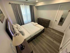 帕特森The Chic Suite - 1BR with Luxe Amenities的一间卧室配有床、灯和窗户