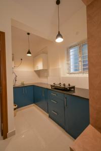 班加罗尔HomeSlice Whitefield - 1BHK/ 2BHK Apartment/ Studio Room的厨房配有蓝色橱柜和蓝色台面