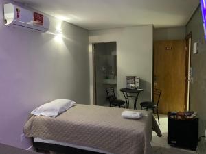 巴西利亚Hotel Oásis的一间卧室配有一张床和一张桌子及椅子