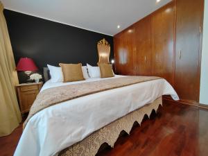 利马ANA FRANK Boutique Hotel的一间卧室设有一张带木墙的大床