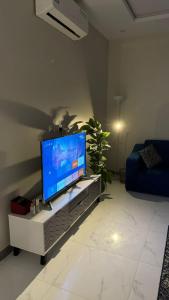 海米斯穆谢特الجود مخيم شقة استراحة بيت的客厅配有餐桌上的平面电视