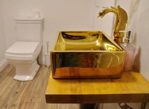 萨弗伦沃尔登Luxury 3 Bed Manor House Hot Tub & Cinema的一间带金色水槽和卫生间的浴室