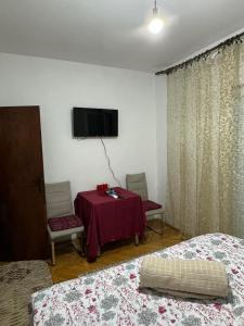 波德戈里察Airport home Radinovic的客房设有两张床、一张桌子和一台电视机。
