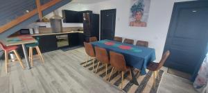 拉波塞雄Villa Belle Vie - Climatisée & Piscine chauffée的一间配备有蓝色桌子和椅子的用餐室