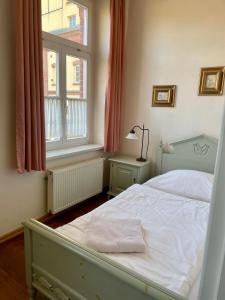 博尔纳Hotel zur Schlossmühle的卧室配有白色的床和窗户。