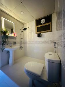 阿布扎比Sunrise Inn by DSV Property的白色的浴室设有卫生间和水槽。
