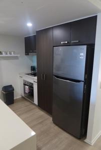巴加拉Ground Floor Luxury Oceanfront Apartment的厨房配有黑色冰箱和炉灶。