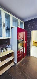 SakumonaThe Hedge的厨房配有白色冰箱和红色橱柜