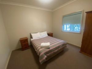 TemoraAirfield Tourist Park Temora的一间小卧室,配有床和窗户