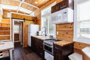 Apple ValleyHarrington Tiny House的铺有木地板,设有木墙厨房。