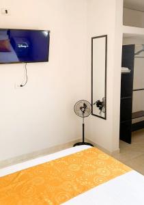 库库塔Acogedor Apartaestudio cerca al aeropuerto的客房设有带风扇和镜子的床。