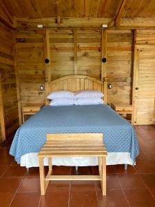 San Juan ChamelcoHotel en Finca Chijul, reserva natural privada的木制卧室配有床和长凳