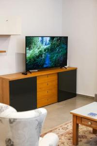 斯利马Lovely 3 bed - Apartment -Sliema的木质娱乐中心顶部的平面电视
