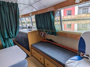 切姆Unique Boat in Chelmsford city的一个小火车房间,设有长凳和窗户