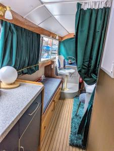 切姆Unique Boat in Chelmsford city的一间小房间,厨房配有绿色窗帘