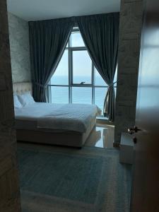 阿吉曼Sunset Beach View Holiday Homes的一间卧室设有一张床和一个大窗户