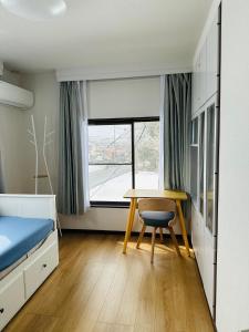 南鱼沼市Urasa Cottage @ Snow Countryside的一间卧室配有书桌、床和窗户。