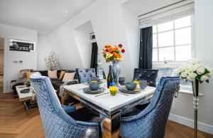 伦敦Marble Arch Penthouse 1 Bed的客厅配有桌子和蓝色椅子