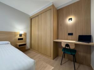 阿尔泰霍欧罗巴酒店的酒店客房配有一张床、一张书桌和一台笔记本电脑