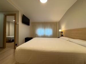 阿尔泰霍欧罗巴酒店的卧室设有一张白色大床和一扇窗户。