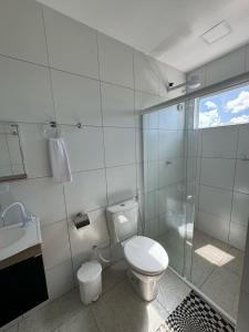 马拉戈日Pousada Hércules Beach Paradise的一间带卫生间和玻璃淋浴间的浴室