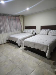波哥大HOTEL CASA MARED Corferias-Embajada Americana的一间带两张床的卧室,铺有瓷砖地板。