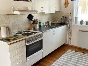 孙讷Holiday home SUNNE IV的厨房配有白色橱柜和炉灶烤箱。
