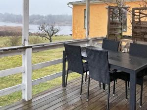 龙讷比Holiday home Ronneby XIII的观景甲板上的一张黑桌和椅子