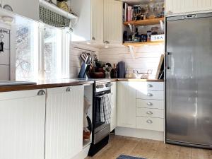 林雪平Holiday home Linköping II的厨房配有白色橱柜和不锈钢冰箱