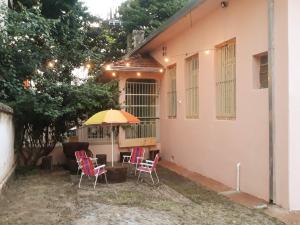 乌贝拉巴Casa Patrimônio Histórico - Centro de Uberaba的房屋前设有带椅子和遮阳伞的天井。