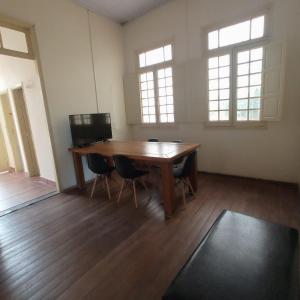 乌贝拉巴Casa Patrimônio Histórico - Centro de Uberaba的空房间,设有木桌和两个窗户