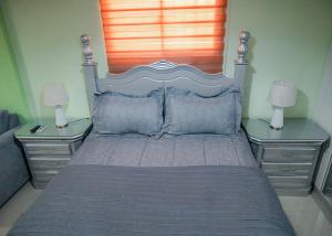 圣佩德罗-德马科里斯Suite in San Pedro De Macoris的一间卧室配有一张带2个床头柜的大床