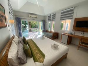 Ban Nong SuaChang Noi Hua Hin Pranburi fully accessible barrierefrei resort的一间卧室配有一张床、一张书桌和一台电视