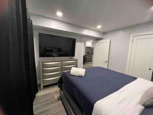 帕特森The Homey Suite - 1BR with Luxe Amenities的一间卧室配有一张床和一台平面电视