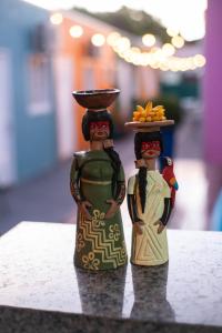 博尼图Baru Bonito - Suítes的两个人站在桌子上的两个雕像