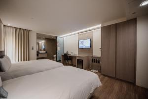 高雄旅居文旅 高雄亚湾馆的酒店客房配有两张床和一张书桌
