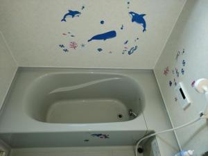 千仓町シーカレント　ゆな　CHIKURA的浴室配有带鱼墙贴花的浴缸。