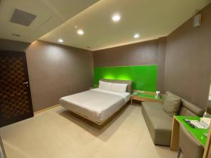 屏东县进成旅社 的一间卧室设有一张床和绿色的墙壁