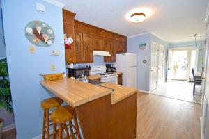 大洋城海杰联排别墅616C公寓的厨房配有木制橱柜和台面