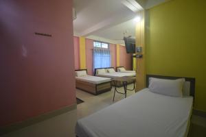 GogāmukhHOTEL CKD的小房间设有两张床和一张桌子